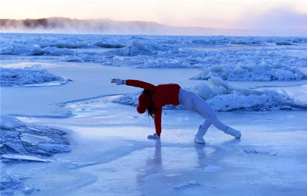 Yoga enthusiasts practice on frozen river in Heilongjiang