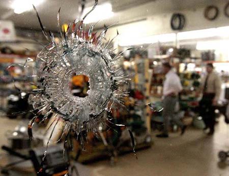 Investigators work at one scene of a shooting spree in downtown Samson, Alabama March 10, 2009. At least 10 people including the suspected gunman and his mother were killed in the shooting spree and car chase in southern Alabama on Tuesday, 